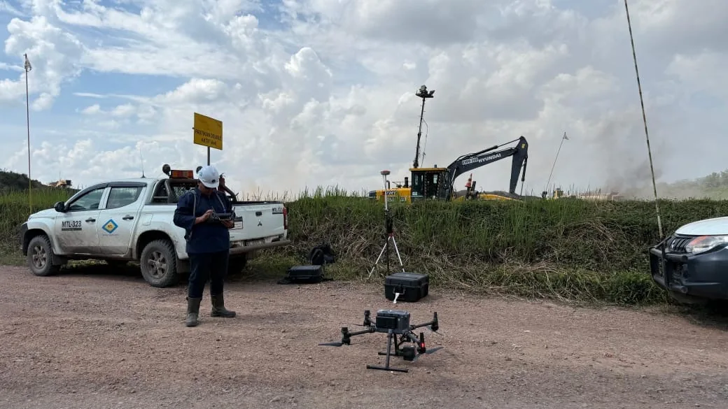 Operator Anugerah Lens mengoperasikan drone pemetaan di lokasi tambang dengan base station RTK dan alat berat